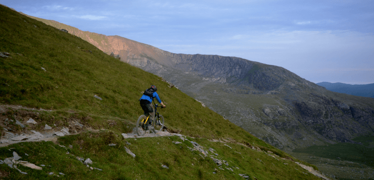 A mountain biker rides down an easier section of the Snowdon Ranger Path.